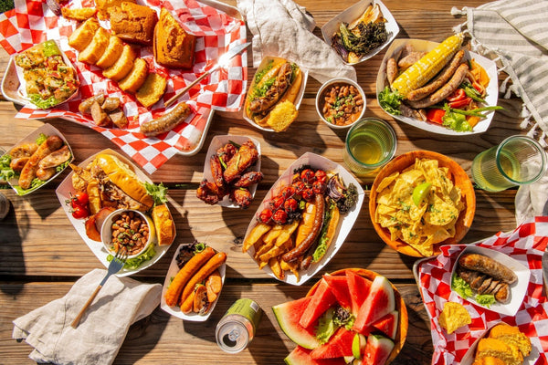 Outdoor gourmet picnic spread with Dufour Gourmet sausages, bread, grilled vegetables, and summer sides
