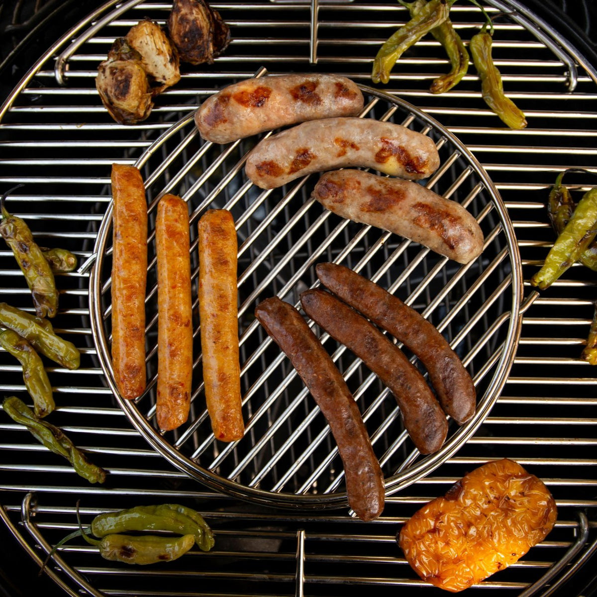 BBQ Trio Sampler with pork and cheese, merguez, and Thai-style chicken sausages on a grill